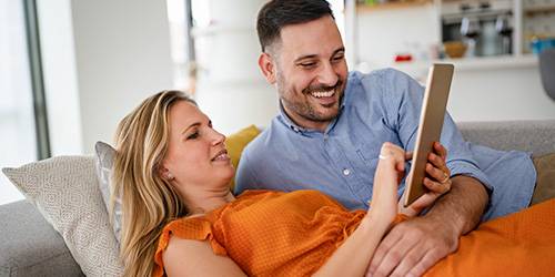 Auf der Couch liegenden Paar mit Tablet
